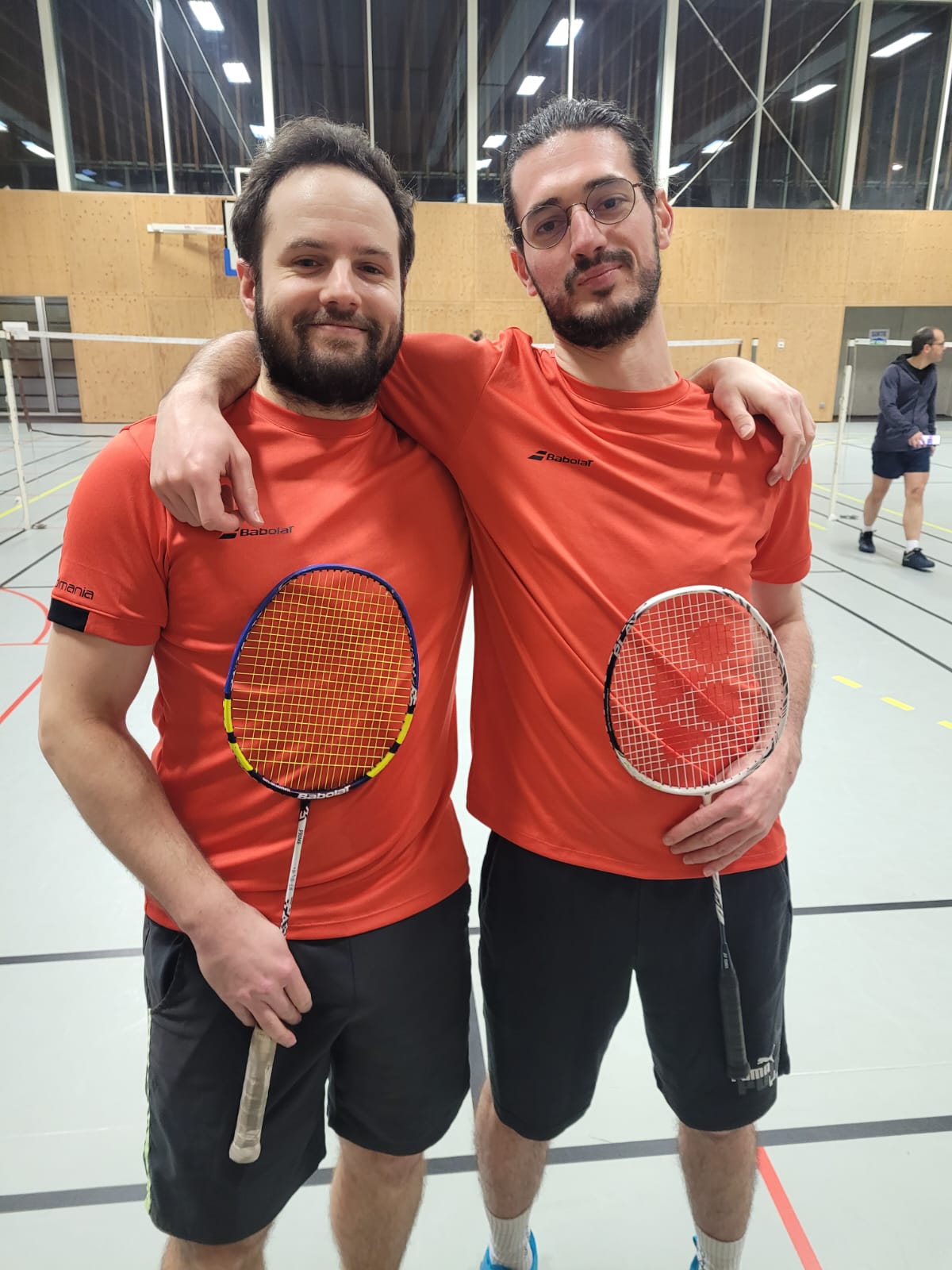 Deux joueurs en tenue rouge après une rencontre de badminton